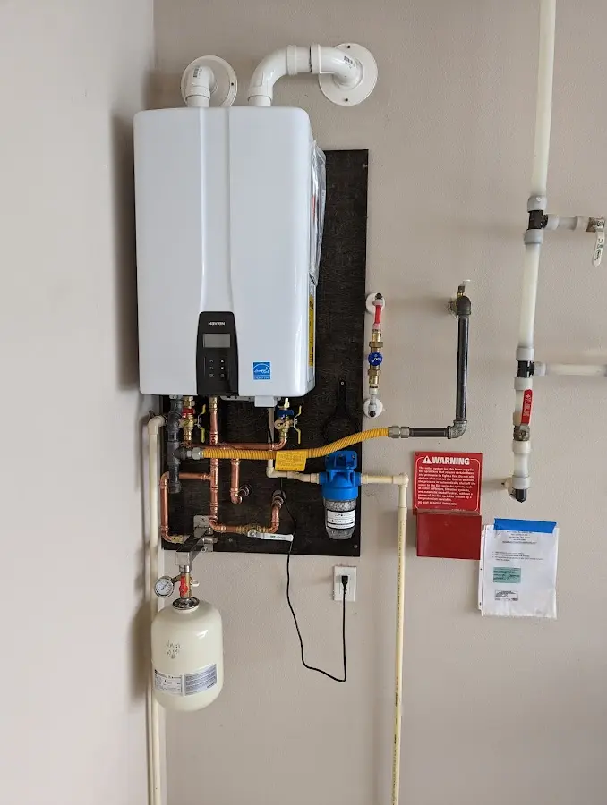 Professional plumber installing copper piping in a North Branford home